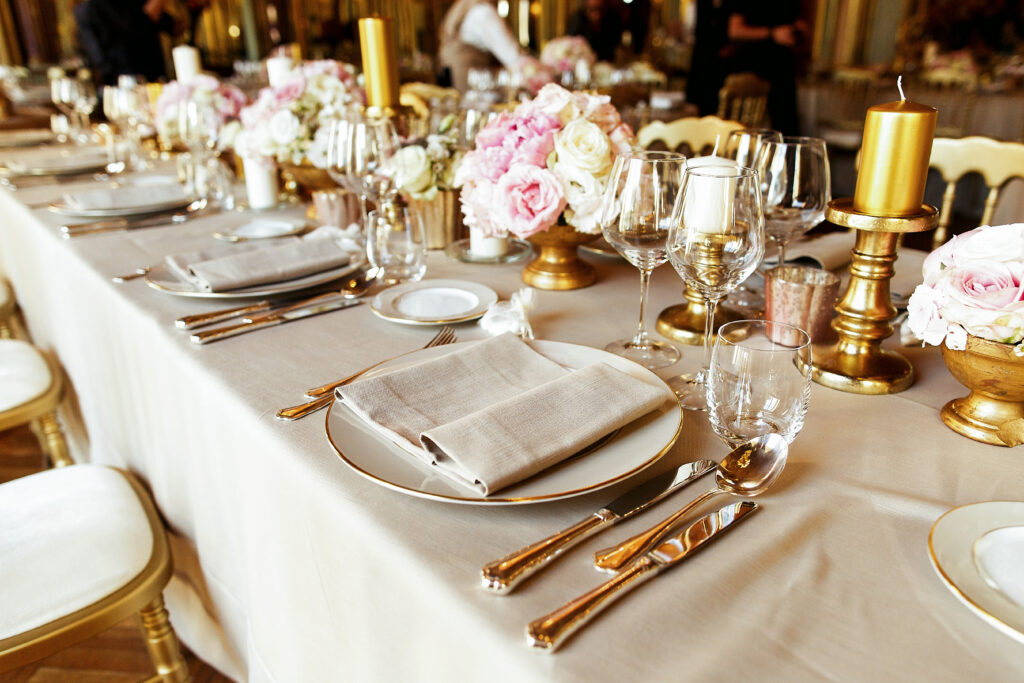 shiny glassware and cutlery stand on the dinner table decorated